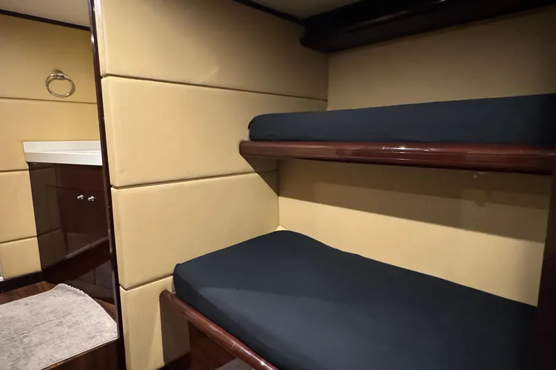 True North Yacht Photos Pics Interior of 2011 Hargrave Tri Deck yacht with bunk beds and elegant wood finish.
