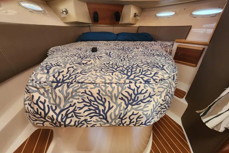  Yacht Photos Pics 2021 Cutwater C-32 CB cabin with coral-patterned bedding and wooden accents.