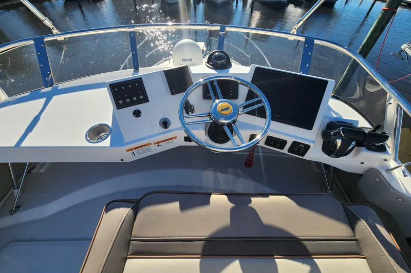  Yacht Photos Pics 2021 Cutwater C-32 CB helm with steering wheel, controls, and navigation screens.
