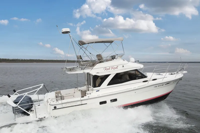  Yacht Photos Pics 2021 Cutwater C-32 CB boat cruising on open water under a clear blue sky.