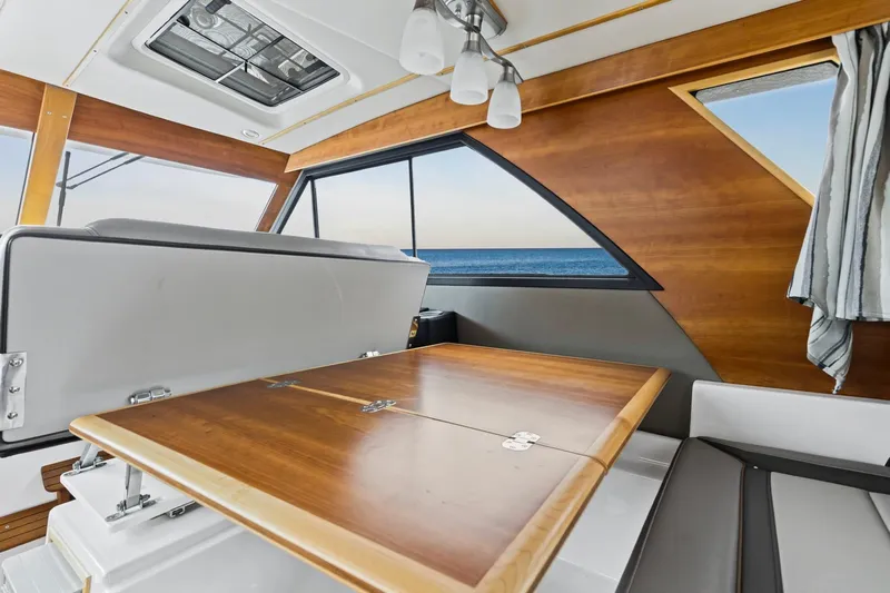  Yacht Photos Pics Interior of 2021 Cutwater C-32 CB boat with wooden table and ocean view.