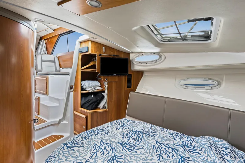  Yacht Photos Pics 2021 Cutwater C-32 CB cabin interior with bed, storage, and seating area.