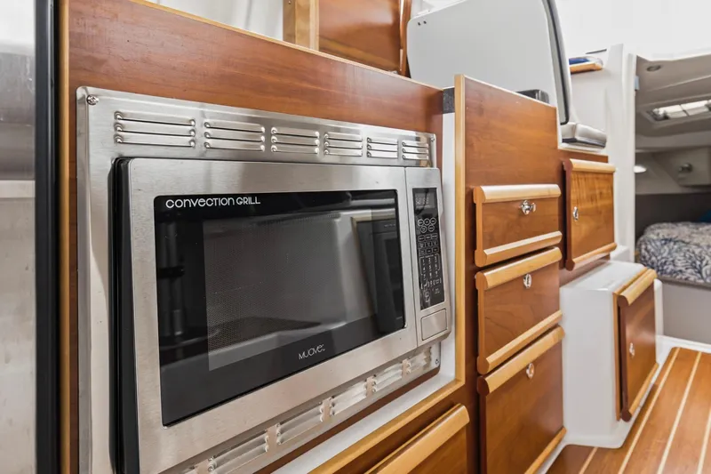  Yacht Photos Pics 2021 Cutwater C-32 CB interior with convection grill and wooden cabinetry.