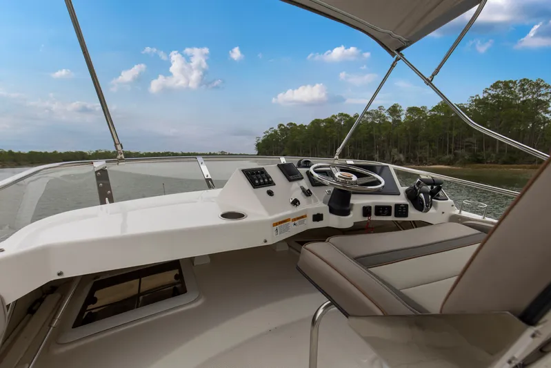  Yacht Photos Pics 2021 Cutwater C-32 CB helm with steering wheel, controls, and seating, overlooking serene waters.
