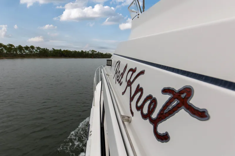  Yacht Photos Pics 2021 Cutwater C-32 CB boat cruising on a calm lake under a partly cloudy sky.