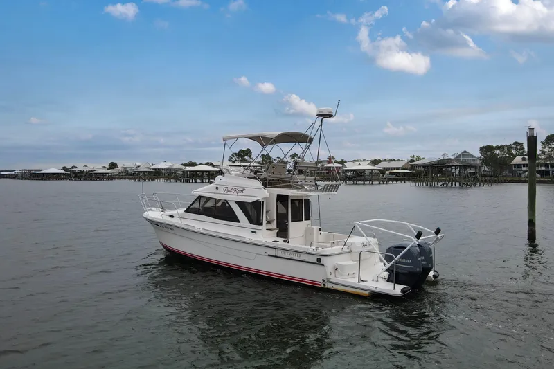  Yacht Photos Pics 2021 Cutwater C-32 CB boat on calm water with coastal background.