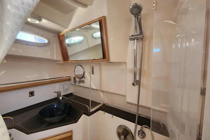  Yacht Photos Pics 2021 Cutwater C-32 CB yacht bathroom with modern fixtures and porthole windows.