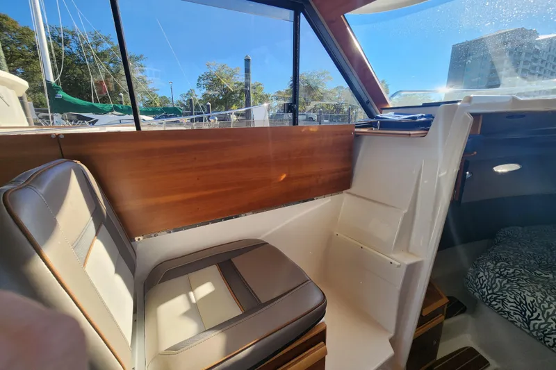  Yacht Photos Pics 2021 Cutwater C-32 CB interior with wood paneling and cushioned seating.