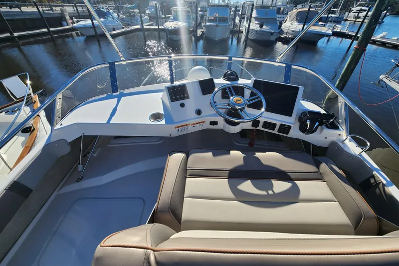  Yacht Photos Pics 2021 Cutwater C-32 CB boat helm with modern controls and marina view.