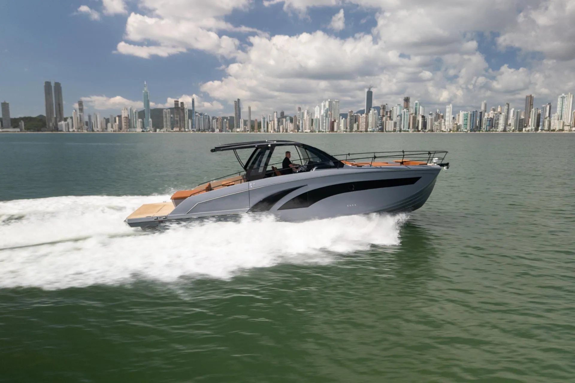 2026 Hanover 447 yacht cruising on water with city skyline in background.