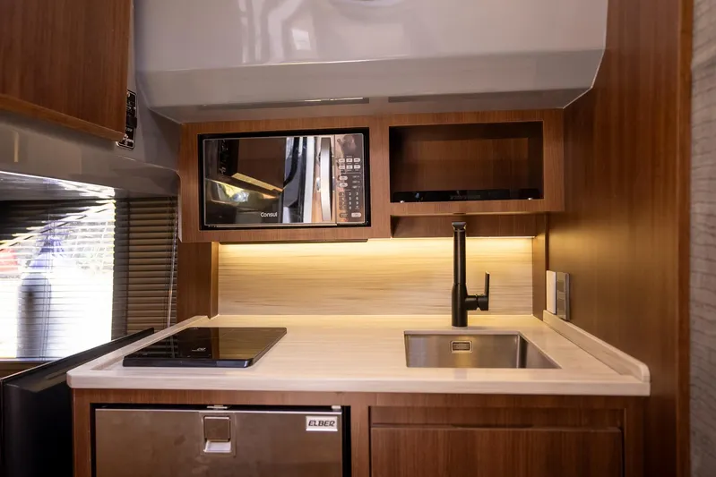  Yacht Photos Pics Modern kitchen in 2026 Hanover 447 RV with microwave, sink, and induction cooktop.