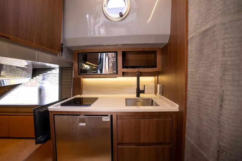  Yacht Photos Pics Modern kitchen in 2026 Hanover 447 yacht with wood cabinetry and stainless steel appliances.