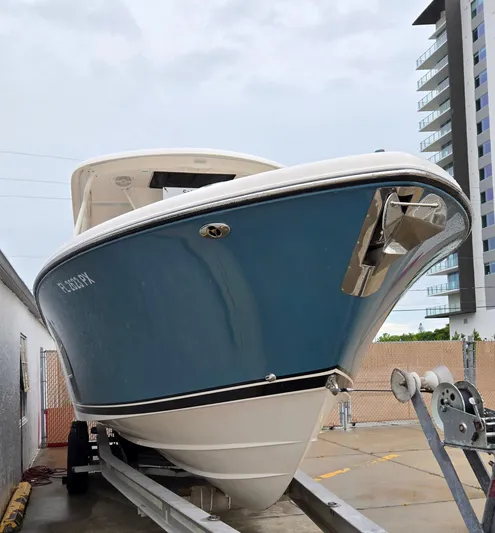  Yacht Photos Pics 2015 Pursuit S280 boat on trailer, blue hull, urban background.