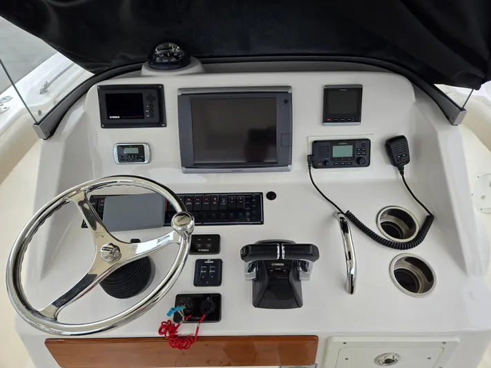  Yacht Photos Pics Control panel of a 2015 Pursuit S280 boat with steering wheel and navigation equipment.