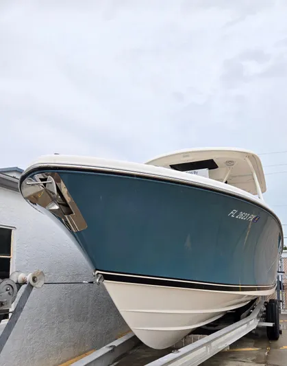  Yacht Photos Pics 2015 Pursuit S280 boat on trailer, blue hull, side view.