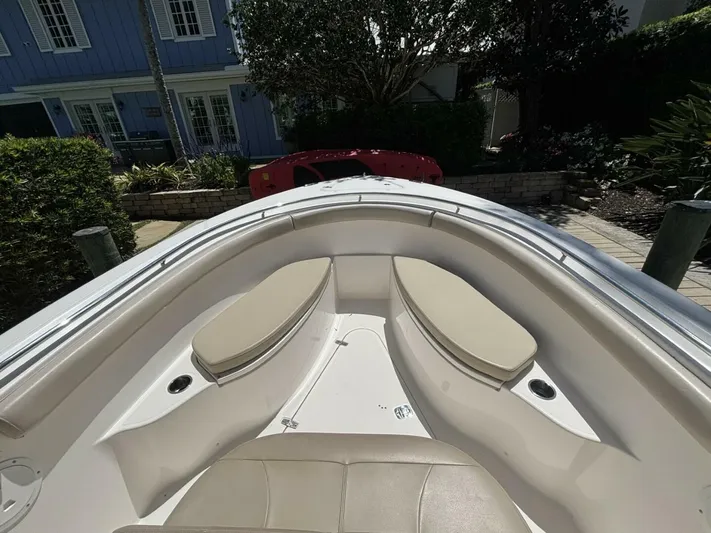  Yacht Photos Pics 2015 Pursuit S280 boat interior with cushioned seating, docked near a house.