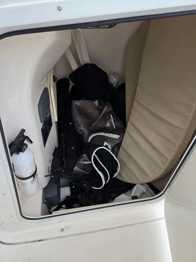 Yacht Photos Pics Storage compartment in a 2015 Pursuit S280 boat, containing gear and a fire extinguisher.