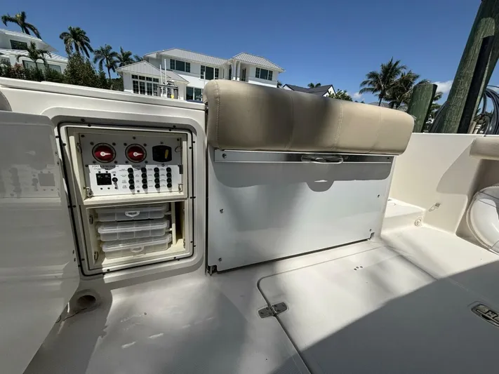  Yacht Photos Pics 2015 Pursuit S280 boat interior with control panel and storage, set against a sunny backdrop.