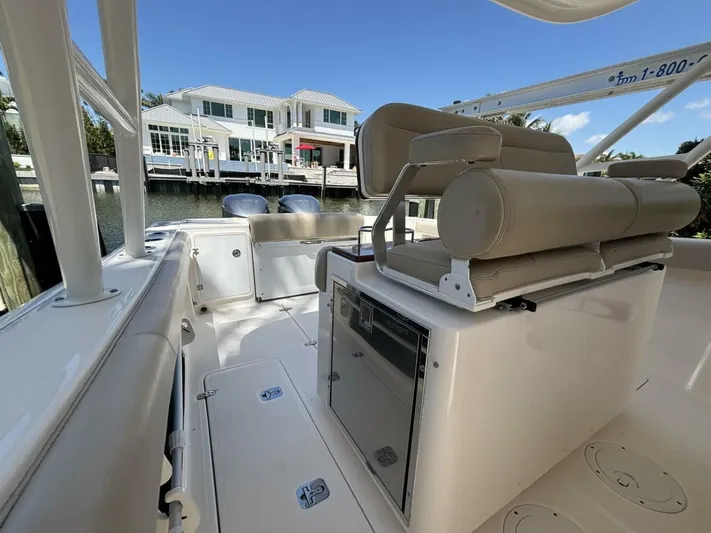  Yacht Photos Pics 2015 Pursuit S280 boat interior with seating, docked near waterfront homes.