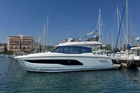 Luxury 2020 Prestige 420 yacht docked in a marina under clear blue skies.