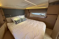Luxurious bedroom interior of 2020 Prestige 420 yacht with modern design and cozy bedding.