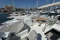 Flybridge of 2020 Prestige 420 yacht in marina, featuring seating and table.