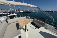 Flybridge of 2020 Prestige 420 yacht with seating and table, docked in marina.