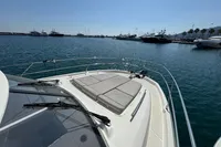 Prestige 420 yacht (2020) with sunbathing area, docked in a marina under clear skies.