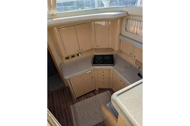 Smitten Yacht Photos Pics 2000 Sea Ray 420 Aft Cabin kitchen with wooden cabinets and modern appliances.