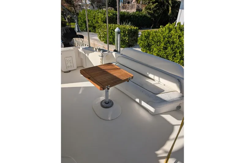 Smitten Yacht Photos Pics 2000 Sea Ray 420 Aft Cabin yacht deck with wooden table and cushioned seating.