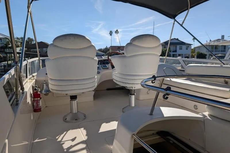 Smitten Yacht Photos Pics 2000 Sea Ray 420 Aft Cabin boat interior with helm chairs and canopy.