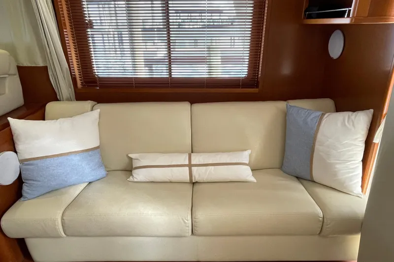 Miss Adventure Yacht Photos Pics Luxurious interior of 2013 Beneteau Swift Trawler 44 with beige sofa and decorative pillows.