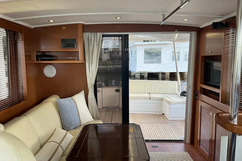 Miss Adventure Yacht Photos Pics Interior of 2013 Beneteau Swift Trawler 44, featuring elegant wood and cream upholstery.
