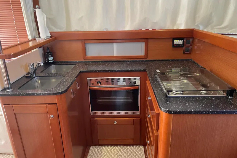 Miss Adventure Yacht Photos Pics 2013 Beneteau Swift Trawler 44 kitchen with wood cabinetry, dual sink, stove, and oven.