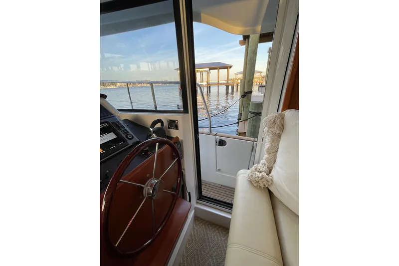 Miss Adventure Yacht Photos Pics Interior view of 2013 Beneteau Swift Trawler 44, showcasing helm and waterfront scenery.