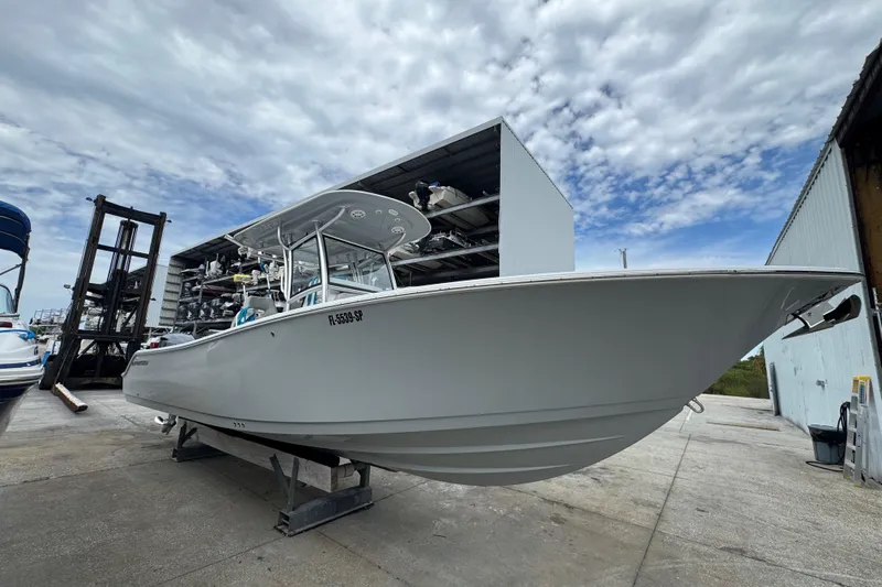  Yacht Photos Pics 2020 Sportsman Open 282TE Center Console boat in storage facility under cloudy sky.
