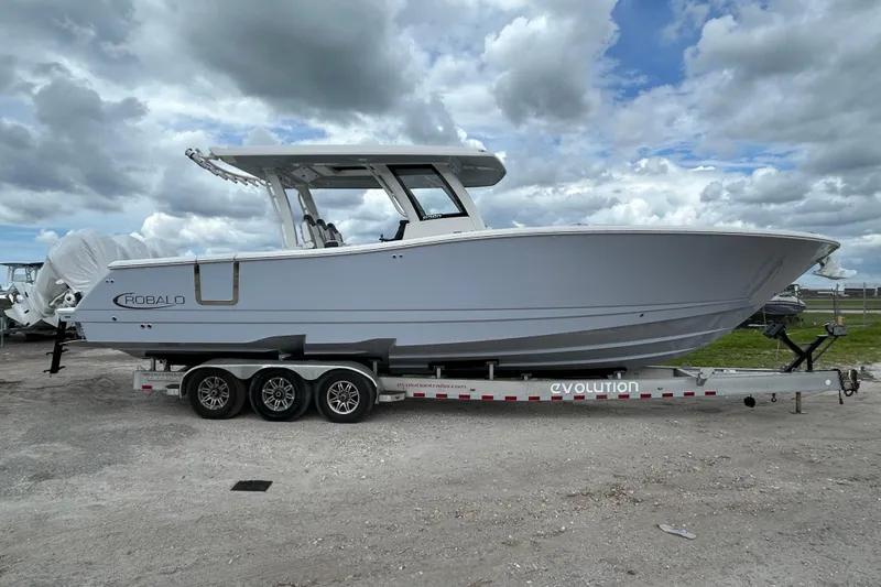  Yacht Photos Pics 2026 Robalo R360 Center Console boat on trailer under cloudy sky.