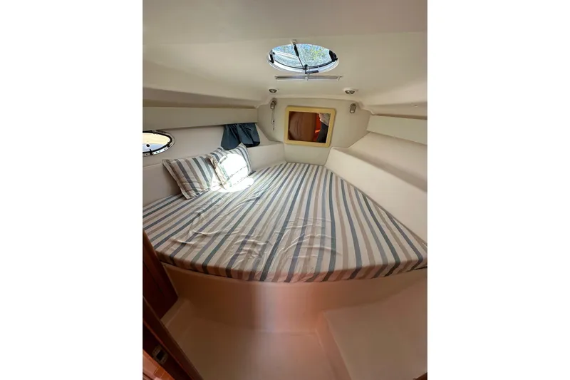 Piccopi Yacht Photos Pics 2007 Mano Marine 32.50 Sport cabin with striped bedding and porthole window.