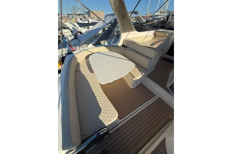 Piccopi Yacht Photos Pics 2007 Mano Marine 32.50 Sport boat interior with cushioned seating and table.