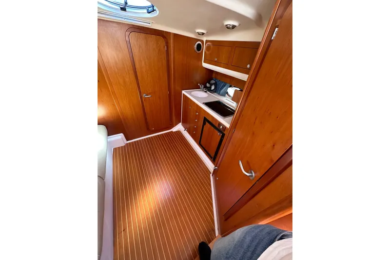 Piccopi Yacht Photos Pics Interior of 2007 Mano Marine 32.50 Sport boat, featuring wooden cabinetry and flooring.