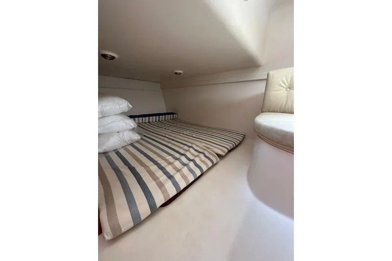Piccopi Yacht Photos Pics Interior cabin of 2007 Mano Marine 32.50 Sport with striped bedding and cushions.