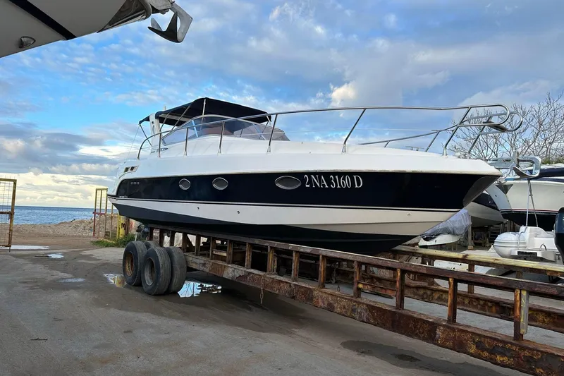 Piccopi Yacht Photos Pics 2007 Mano Marine 32.50 Sport boat on trailer by the sea under a cloudy sky.