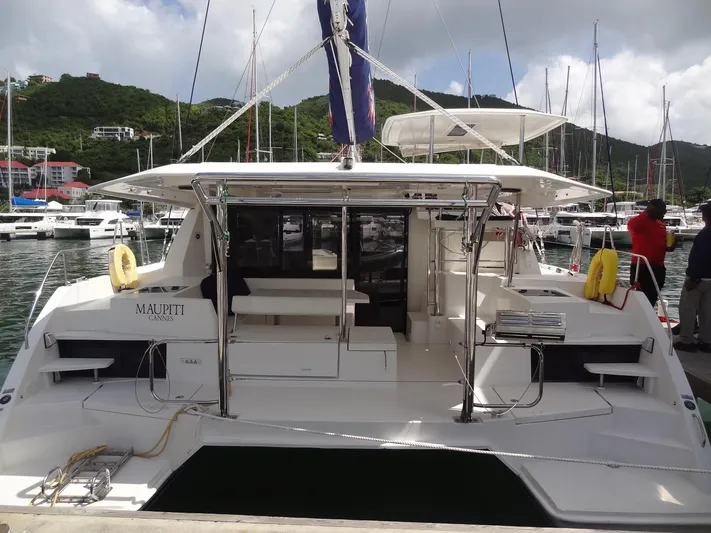 Maupiti Yacht Photos Pics 2019 Leopard 40 catamaran docked at a marina with lush green hills in the background.