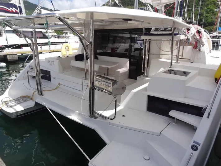 Maupiti Yacht Photos Pics 2019 Leopard 40 catamaran docked at marina, featuring spacious outdoor seating and stainless steel grill.