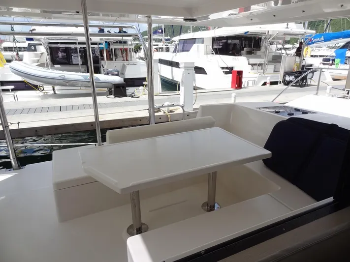 Maupiti Yacht Photos Pics 2019 Leopard 40 catamaran with outdoor seating and table at marina.