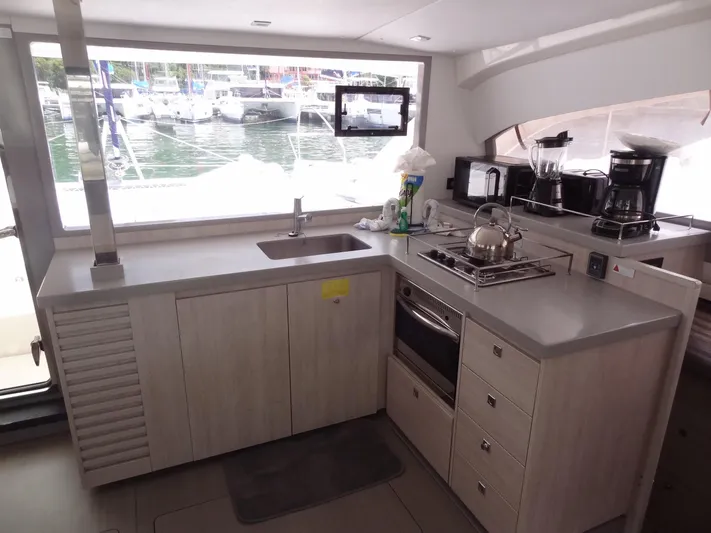 Maupiti Yacht Photos Pics Modern kitchen in a 2019 Leopard 40 catamaran with appliances and marina view.