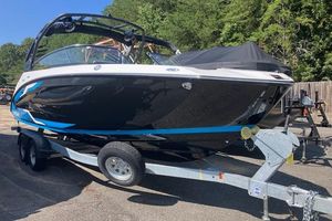 2021 Yamaha Boats 252XE on trailer, black and blue design, parked outdoors.