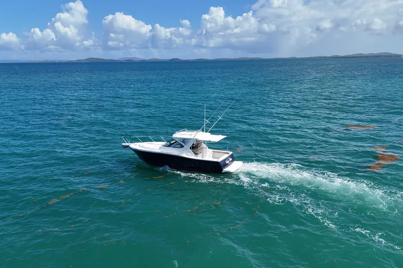  Yacht Photos Pics 2005 Tiara Yachts 3200 Open cruising on clear blue ocean under a partly cloudy sky.