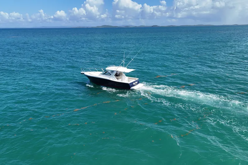  Yacht Photos Pics 2005 Tiara Yachts 3200 Open cruising on clear blue ocean waters.