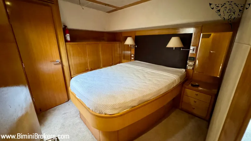  Yacht Photos Pics Luxurious bedroom in 2011 Bertram 800 yacht with wooden furnishings and cozy lighting.